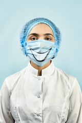 Fototapeta na wymiar Female therapist with funny smiling medical mask
