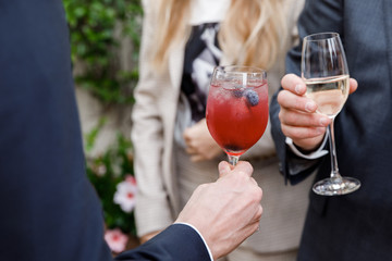 Horizontal close up of Caucasian man in suit and shirt holding a tall glass with wine