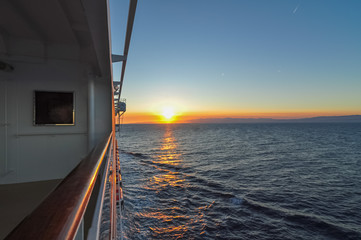 Navire de croisière en navigation avec coucher de soleil.
