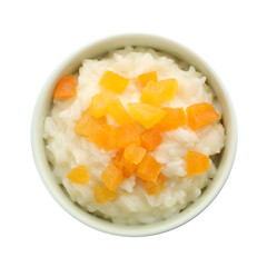 Delicious rice pudding with dried apricots isolated on white, top view