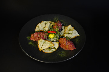 tasty food on a black background, dark background dishes of different countries, plates salads meat
