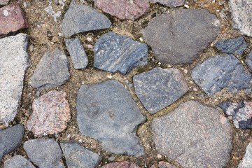 Colorful natural stone pathway. Ancient stone surface with different bricks and sand. Abstract background . 
