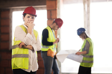 worker, investor, inspector or architect with her team. construction site engineers on site. satisfied expression