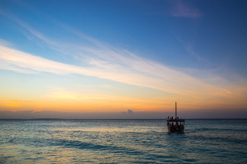 Fototapeta na wymiar Boat on ocean surafe in evening
