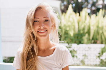 Enchanting young woman wears white clothes posing on nature background. Cute tanned female model...