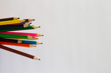 Multi-colored markers and pencils on a white background. School suppliescopyspace for text