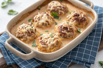 Baked meatballs with cabbage and rice with sour cream sauce