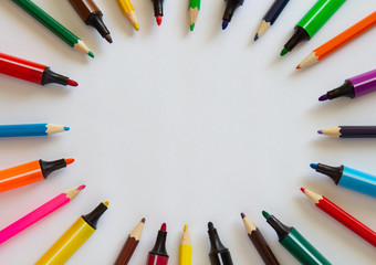 Multi-colored markers and pencils on a white background. School suppliescopyspace for text