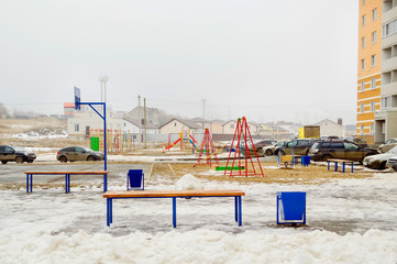 Yard, bench, playground - courtyard in a residential area of Russia, winter.