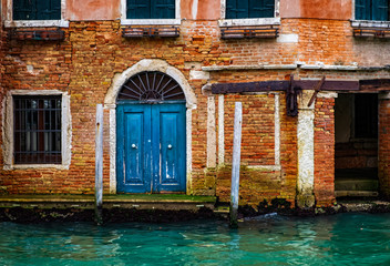 Architectural detail of vintage brick walls, doors and windows in Venice canal, Italy