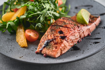 Hot smoked salmon with arugula salad, cherry tomato and orange. Healthy eating.