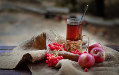 glass of black tea with apples and red berries