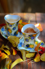 two cups of hot coffee on the table in autumn day