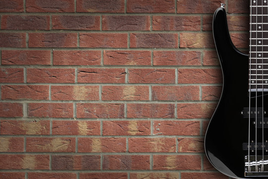 Bass guitar on brick background with copy space