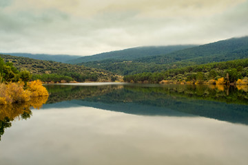 reflections in the river, from the sierra de guadarrama on a day that the fog is coming down