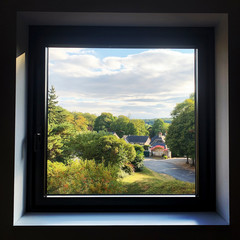 View  through a window of a road going through the countryside in rural France