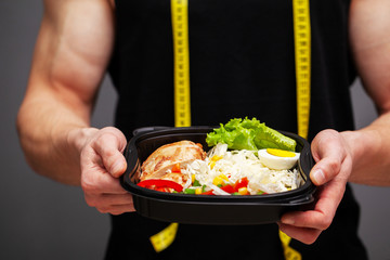 Closeup of a man holding a box full of protein rich foods for sports nutrition