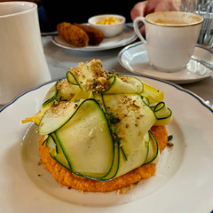 Fresh sliced zucchini on a potato croquettes with toasted nuts 
