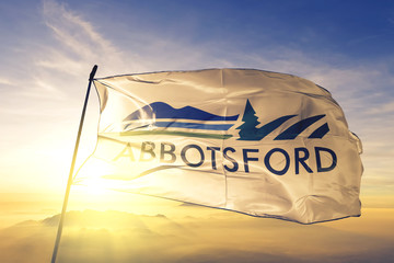 Abbotsford of British Columbia of Canada flag waving on the top sunrise mist fog