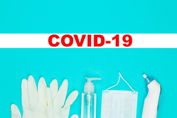 Medical mask, thermometer, white latex gloves and hand sanitizer gel on blue background.