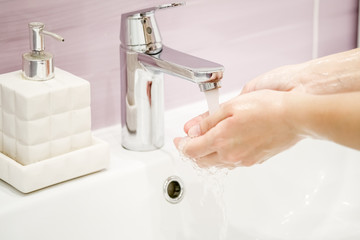 Washing of hands with soap under the crane with water