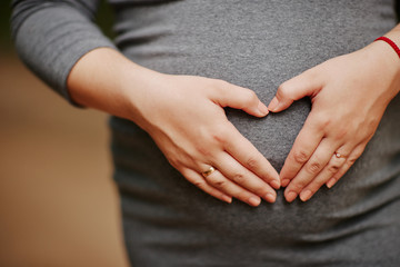 pregnant girl holds belly with hands