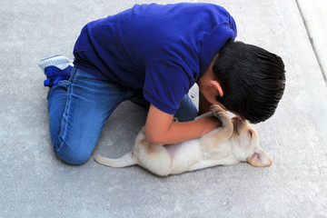 Niño jugando con perro cachorro