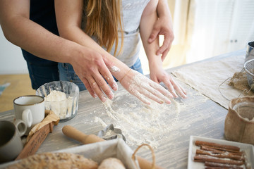 Obraz na płótnie Canvas women's and men's hands mix wheat flour. baker's hand closeup.couple together Cooking pizza, bread