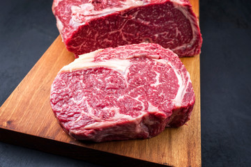 Raw dry aged wagyu entrecote beef steak roast as top view on a modern design wooden board