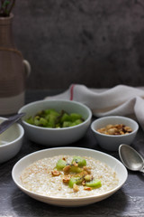 Oatmeal breakfast with butter, kiwi, hazelnuts and cinnamon.