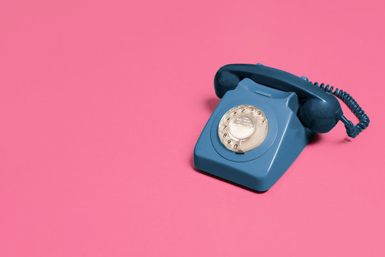 Blue Vintage Antique Rotary Phone On A Pink Background With Copy Space And Room For Text With A Right Side Composition