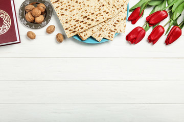Flat lay composition with matzos on white wooden background, space for text. Passover (Pesach)...
