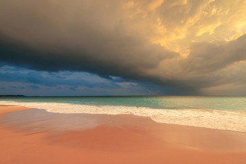 Dramatic stormy sky with heavy clouds over ocean sandy beach. Beautiful sunset landscape on Sri Lanka island.