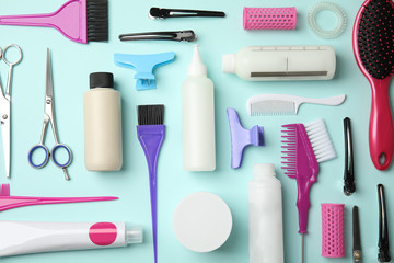 Professional tools for hair dyeing on light blue background, flat lay