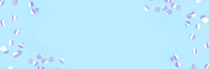 Pearl confetti on blue background. Flat lay, top view.