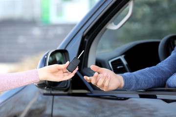 Agent giving key to man in car outdoors, closeup. Buying new auto