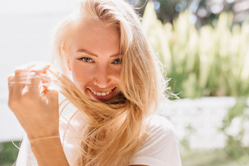Close-up shot of blue-eyed woman playfully looking to camera. Photo of sensual european girl with...