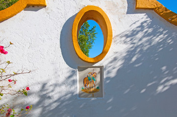 White wall with orange decorations, oval window and spanish tile. Isla Moyor, Seville, Spain