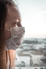 Girl wearing face mask because of air pollution in the city. Adverse ecology. Environmental...