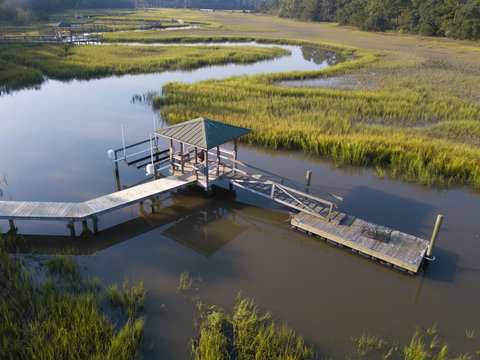 Private dock with boat lift and launch, low aerial view.
