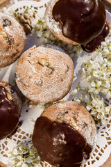 Tasty chocolate cupcakes. Homemade chocolate muffin cupcake with cream buttercream icing. Easter sweet dessert cake. Close up view. Cupcakes in blooming trees. Outdoor shooting in garden.
