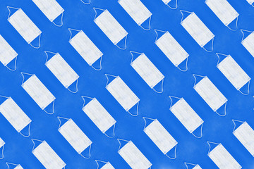 Pattern of face medical masks on navy blue background. Protection from coronavirus. Top view. Flat lay.