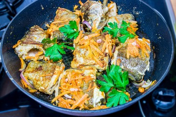 Fry the fish in the pan. Cooking at home. Diet fish with vegetables