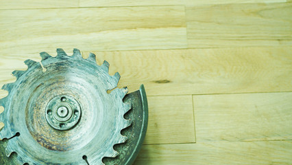 Closeup, prongs of a blade of an old woodworking saw. A circular file for wooden products and firewood against a light oak table.A carpenter's working tool.