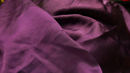 Obraz premium Abstraction, background of silk purple matte fabric. Dark drapery fabric. Satin texture. Beautiful fashionable silk color of fabric.