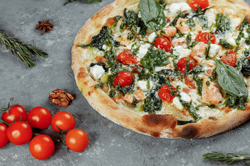 Pizza with salmon, cheese and herbs on a vintage background