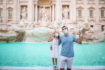 Father and daughter near fountain Fontana di Trevi with coins in hands