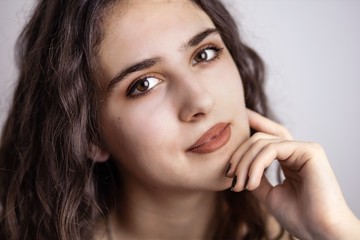 Fototapeta premium Close-up portrait of beautiful brunette teen girl with white background.