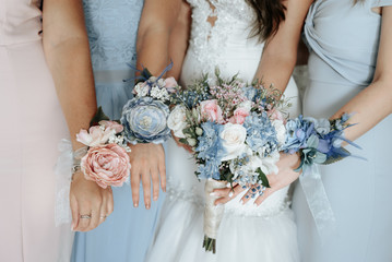 Bride and bridesmaids hand with beautiful flowers. Bridesmaids have control over bouquets