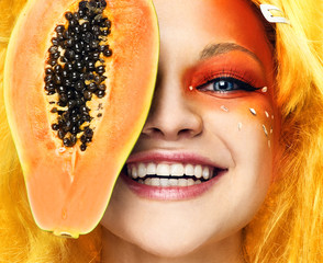 face of a young girl with papaya on a white background - 334584270